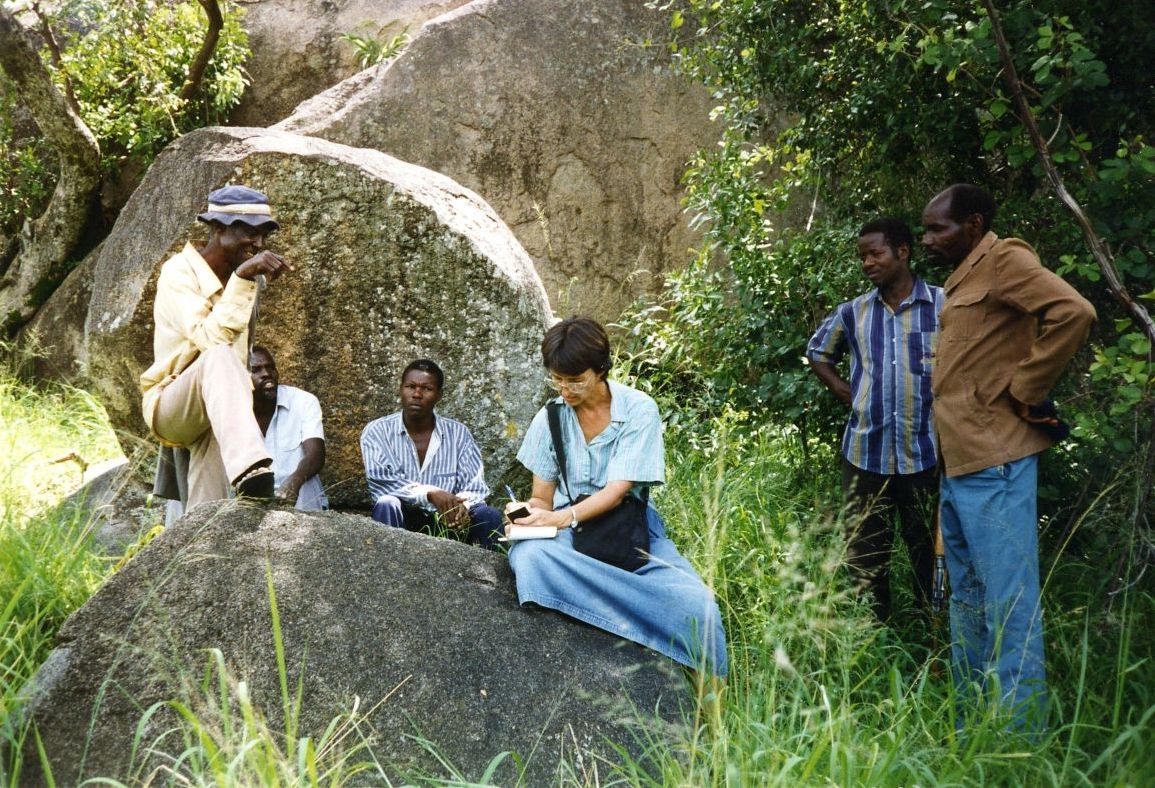 Photograph of (left to right) Sochoro Kabati, Nyawagamba Magotto, an unidentified man, Jan Bender Shetler, an unidentified man, and Joseph Mashohi at site in Bwanda